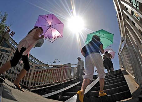 烈日当空,出行的人们撑伞防晒